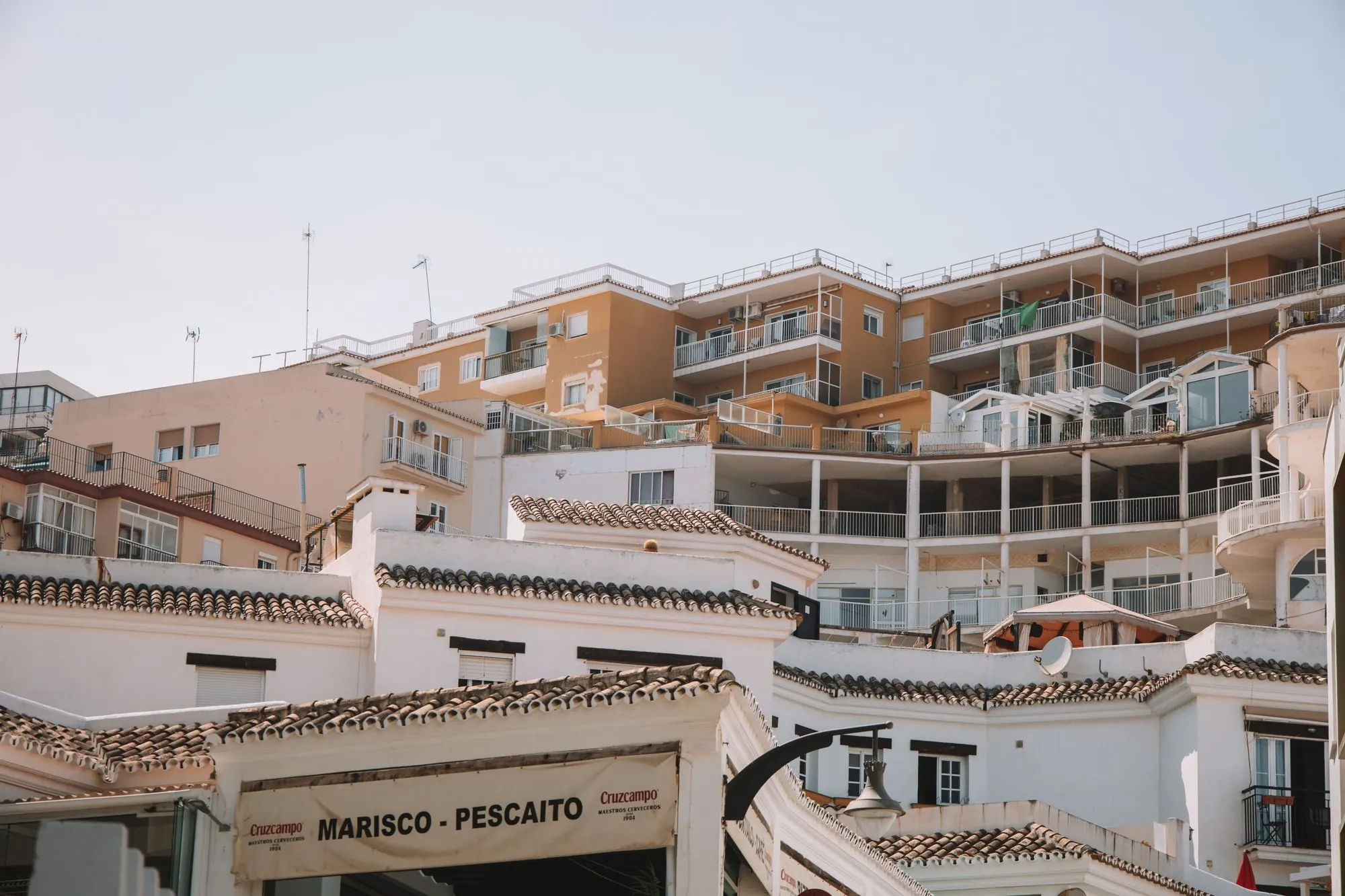 Spaanse appartementen met balkons en pannendaken in een kuststad